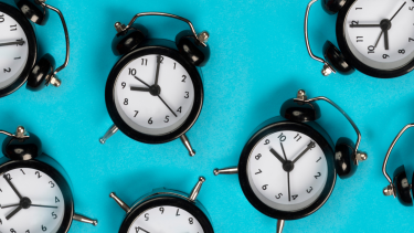 Flat lay of several alarm clocks with blue background